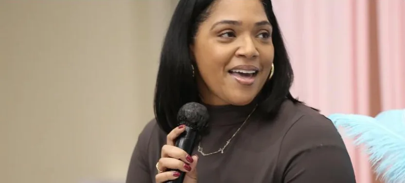 A woman smiles mid-song with a microphone